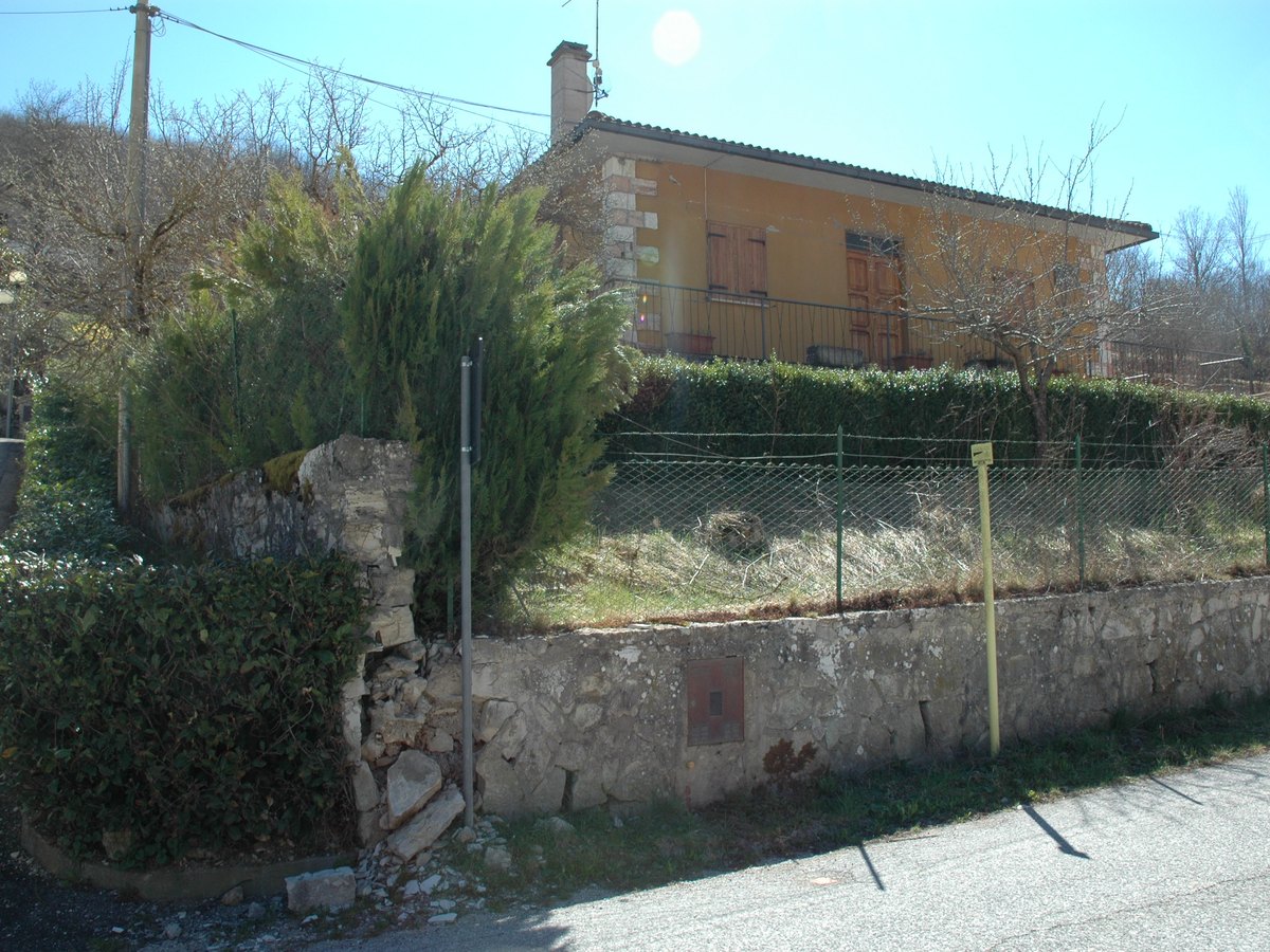 Fabbricato residenziale a Castelsantangelo sul Nera prima dell&rsquo;intervento, visto dalla strada oltre il muro di recinzione in pietra