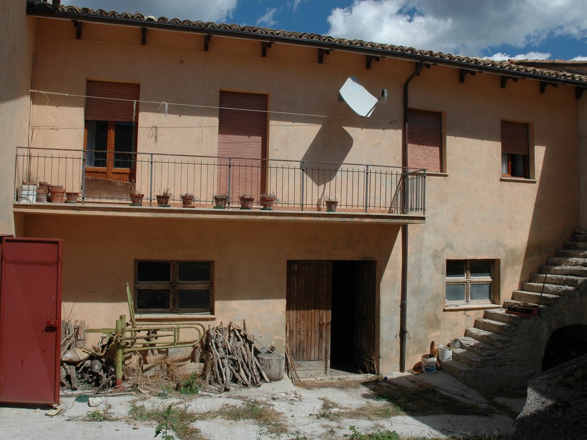 Fabbricato residenziale a Fematre di Visso prima dell&rsquo;intervento: intonaco ammalorato, ballatoio e scala esterna in stato di degrado